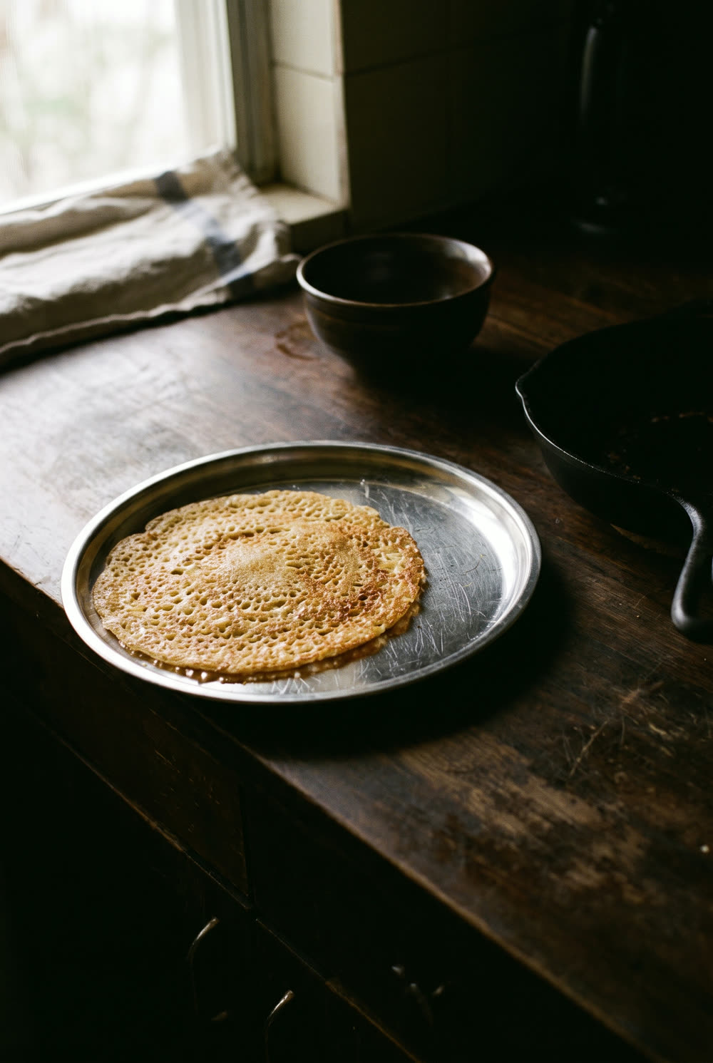 Ghee-roasted rava dosa at six in the morning, lit by one window and a bedsheet diffuser.
